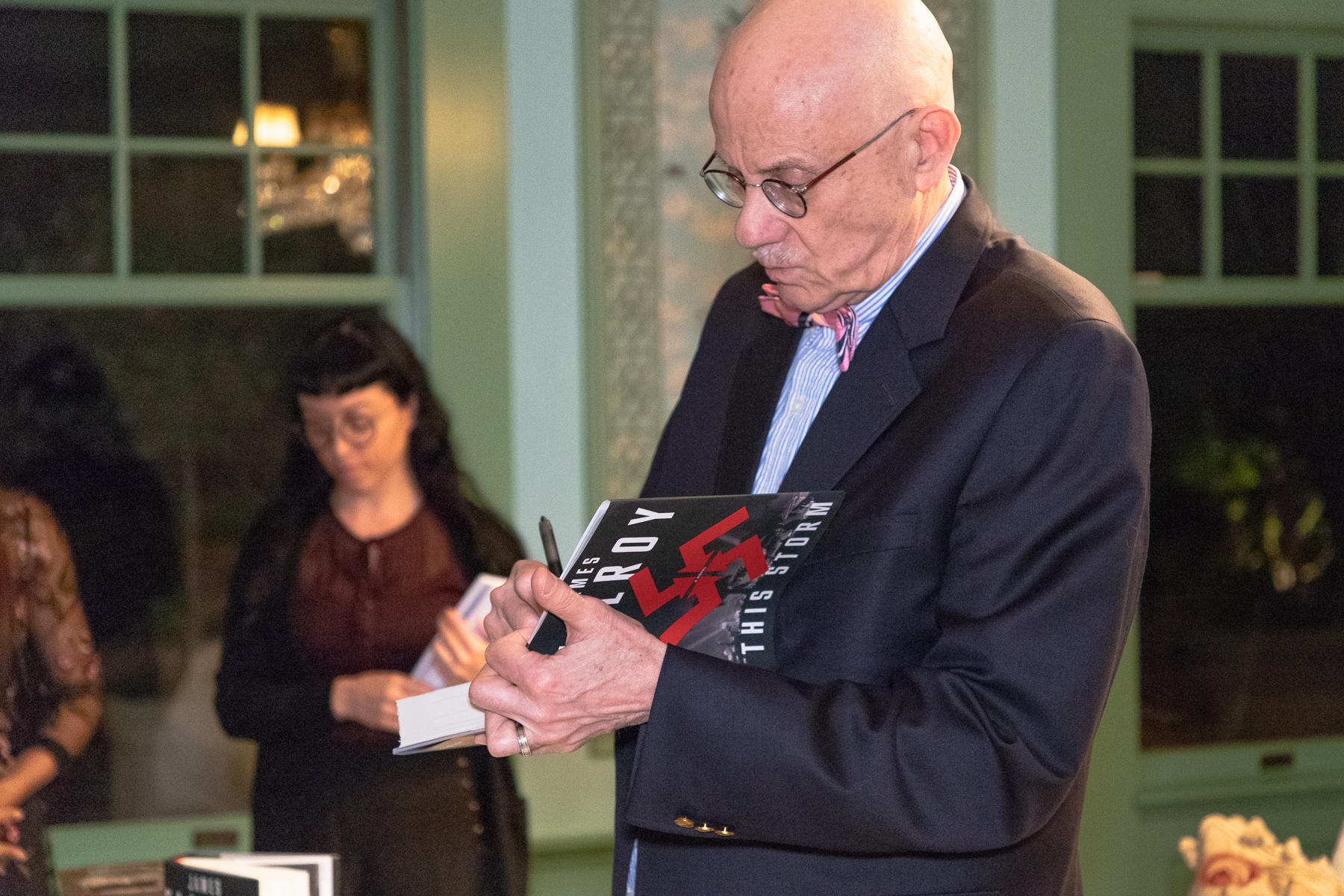 Crime fiction author James Ellroy signing a copy of his latest book This Storm at the LARB Luminary Dinner, Coriolis client event